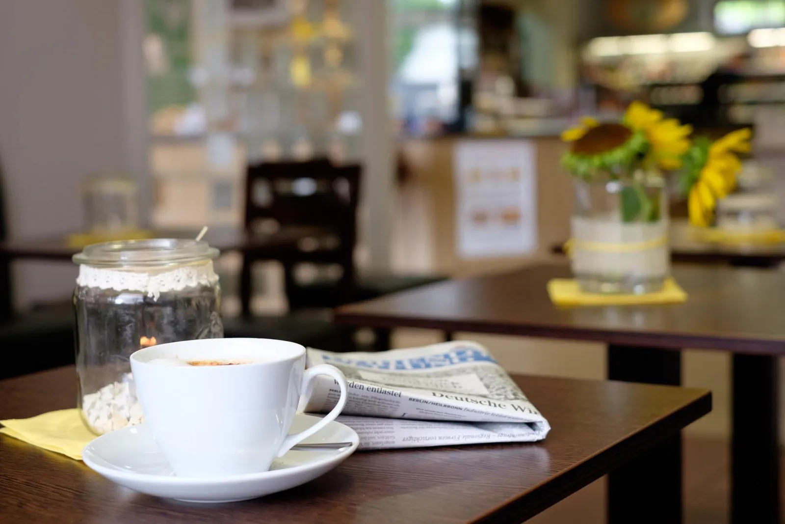Tasse Kaffee mit Zeitung auf einem Holztisch in der Caf&eacute;-Ecke
