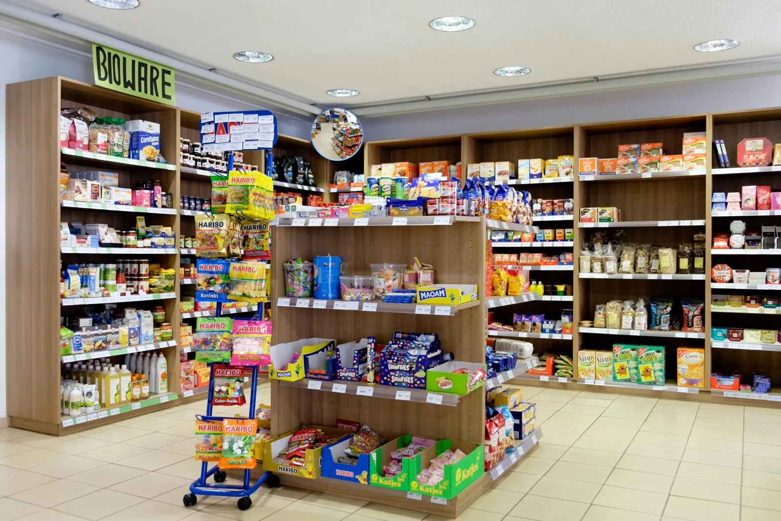 Regalgang im L&auml;dle mit Konserven, Aktionswagen und Holzregalen